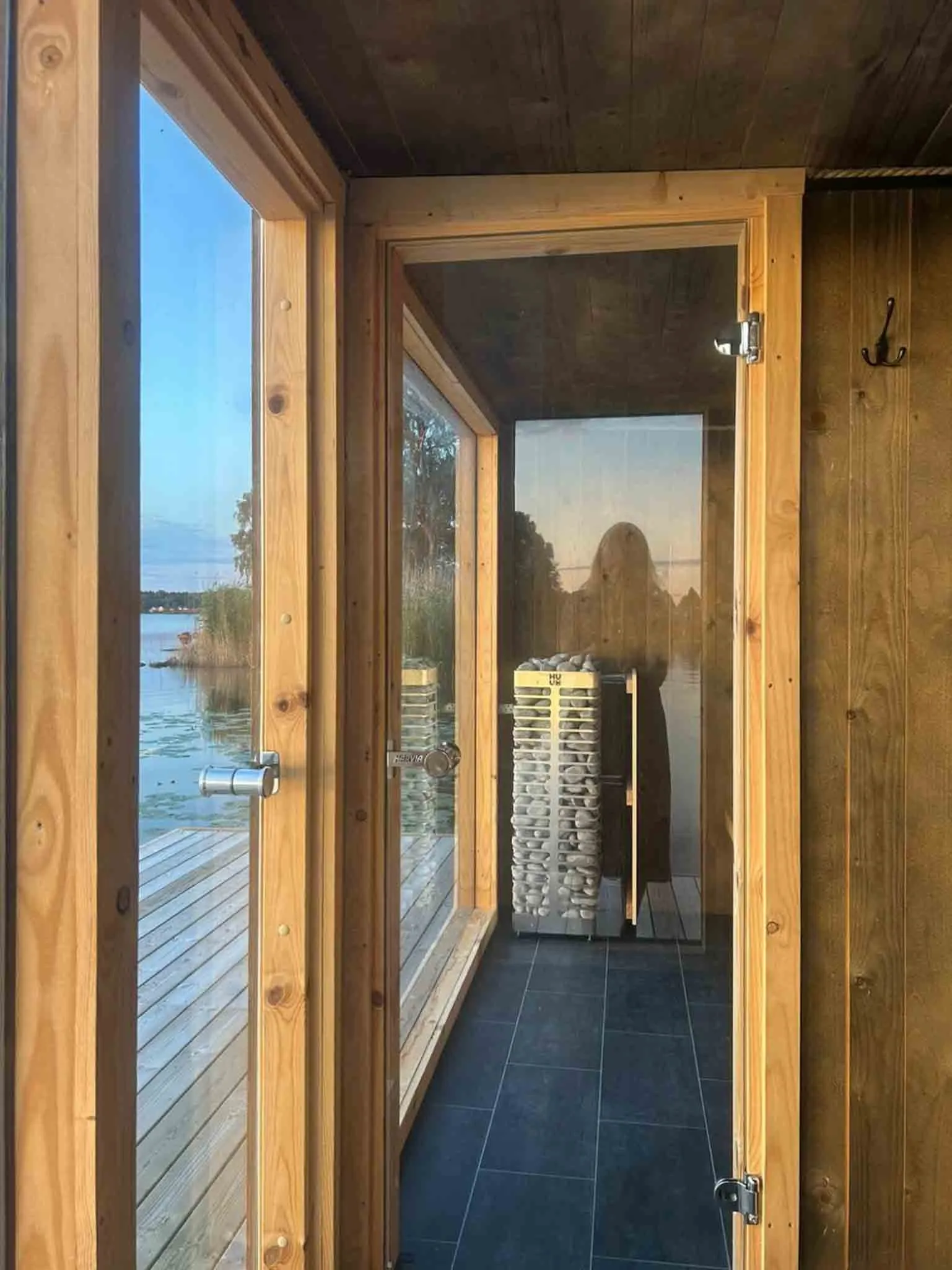 Interior view of Bastuflotten Mariestad sauna with glass walls overlooking Lake Vänern
