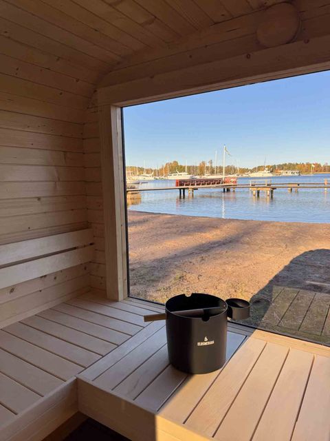 Mobile sauna interior with a large window facing the sea