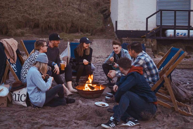 Friends gathered around a campfire on the beach