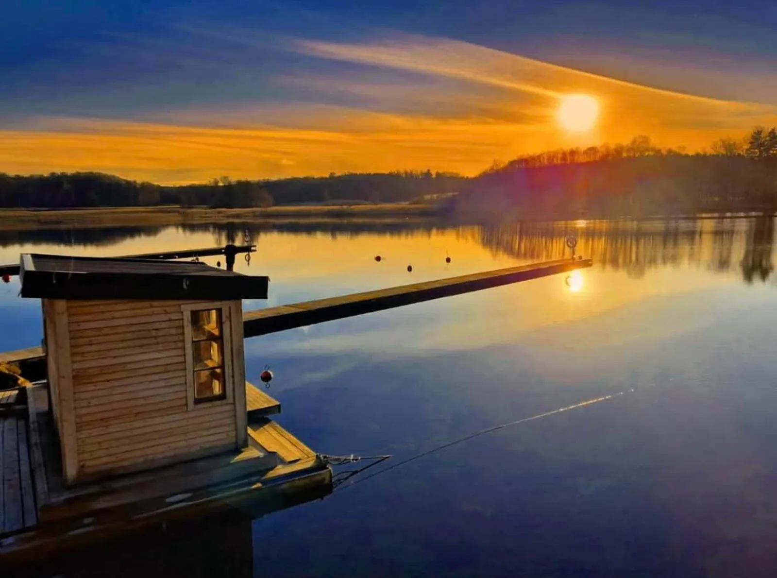 Floating self-service sauna Grebo Bastubåt at sunset on Lake Ärlången