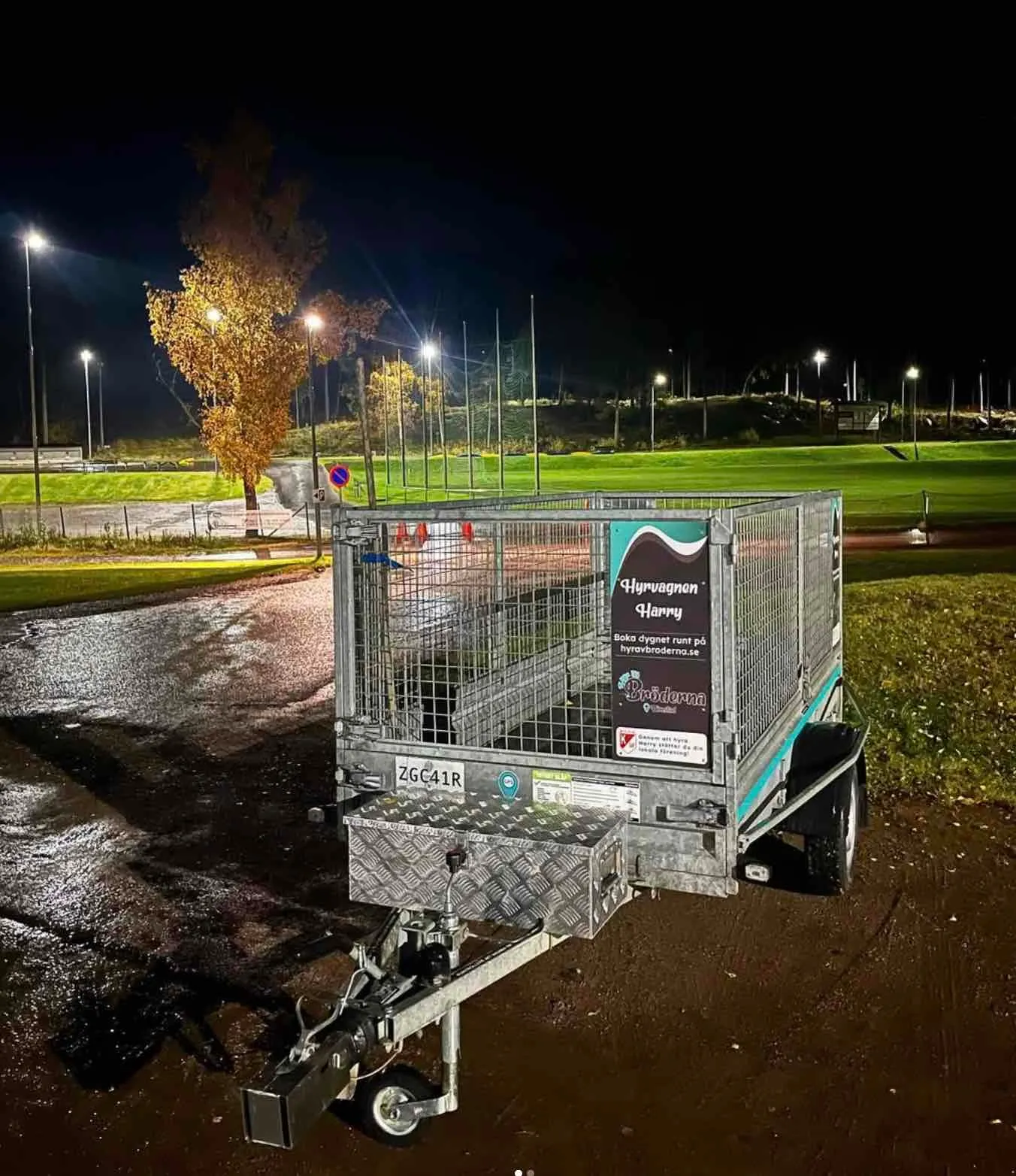 Hyrvagnen Harry parked at a floodlit sports ground at night, ready to be booked through Hyr Av Bröderna’s self-service rental.