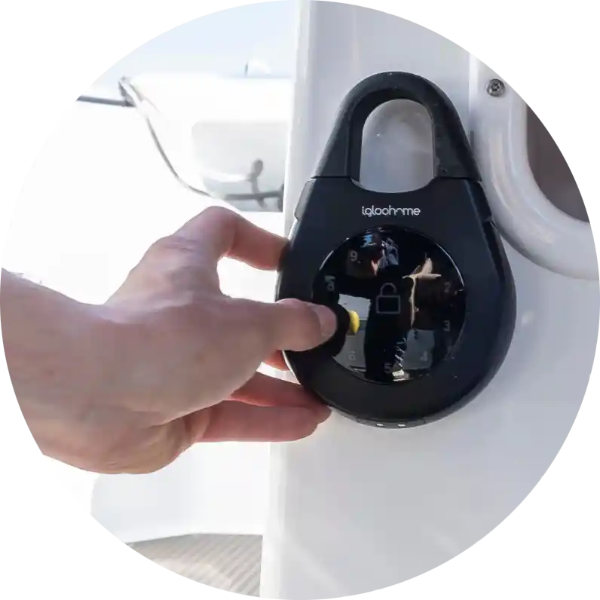 Hand entering a PIN code on an Igloohome Smart Keybox 3 mounted on a boat