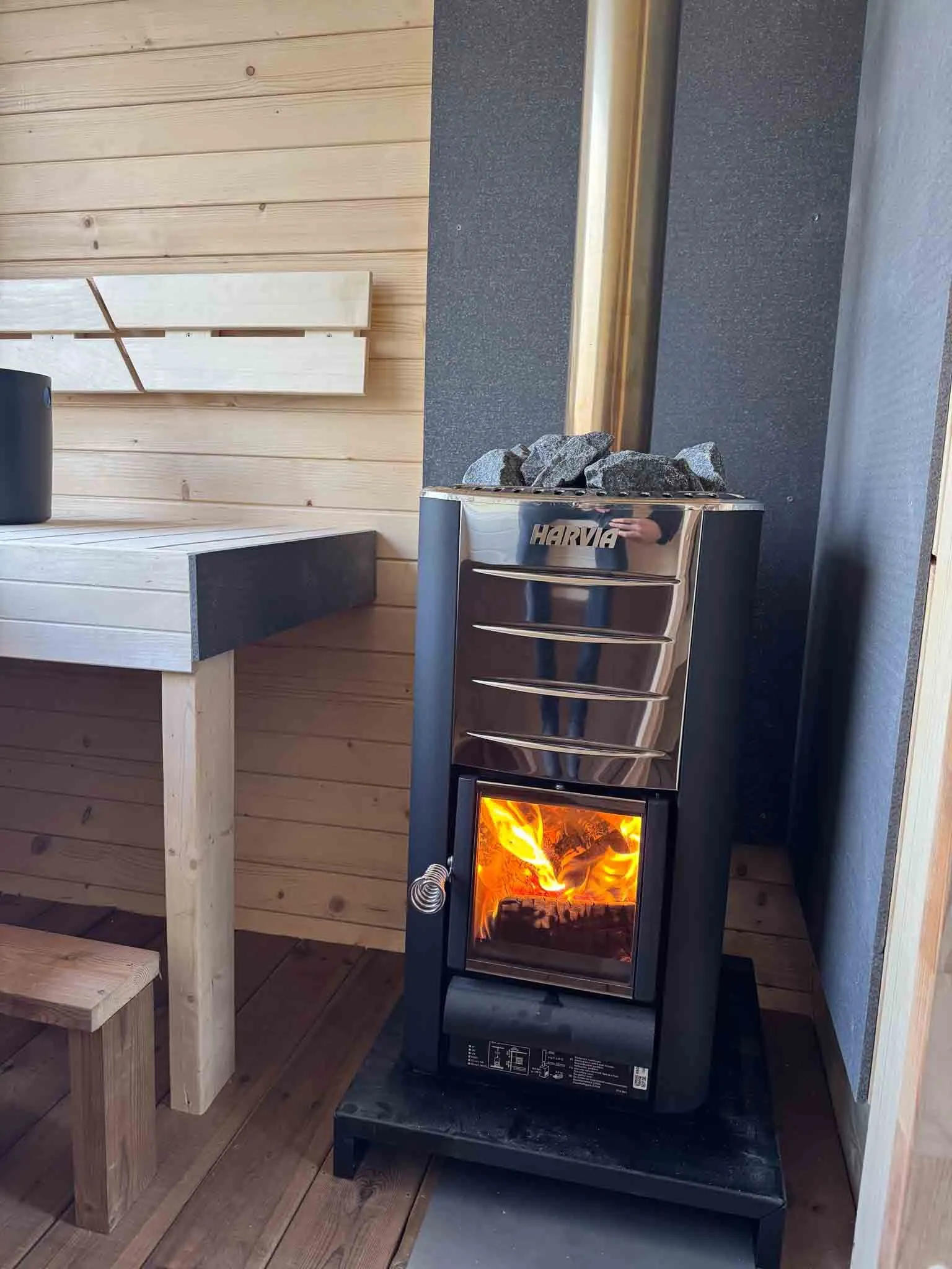 Interior of Lilla Sauna with wooden benches and a Harvia wood-burning heater